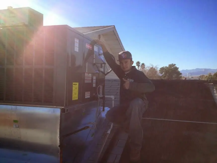 HVAC technician performing Air Duct Cleaning on a rooftop unit in Duluth